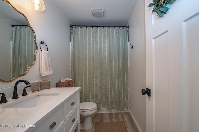 bathroom featuring vanity, a shower with curtain, wood finished floors, visible vents, and toilet