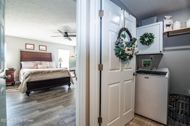 interior space with wood finished floors, washer / clothes dryer, cabinet space, ceiling fan, and a textured ceiling