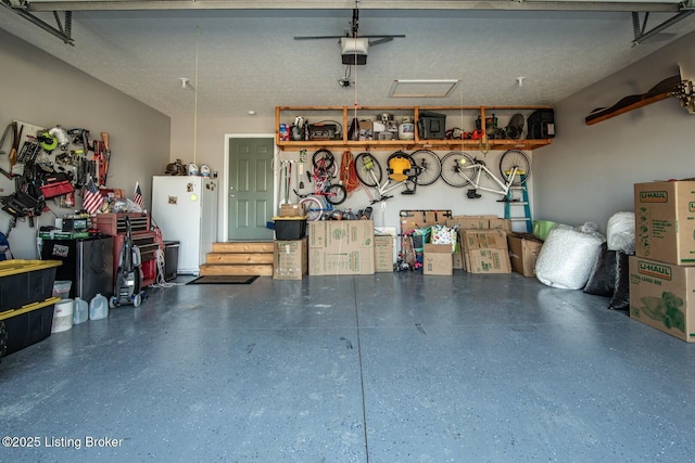 garage featuring a garage door opener and freestanding refrigerator