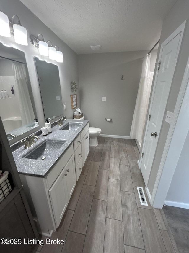 bathroom with a sink, visible vents, and wood finish floors