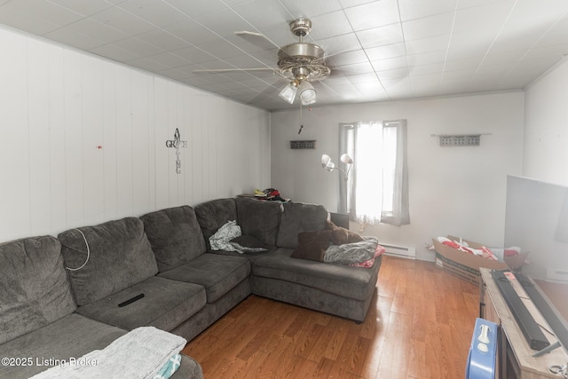 living area featuring wood finished floors, baseboard heating, and ceiling fan