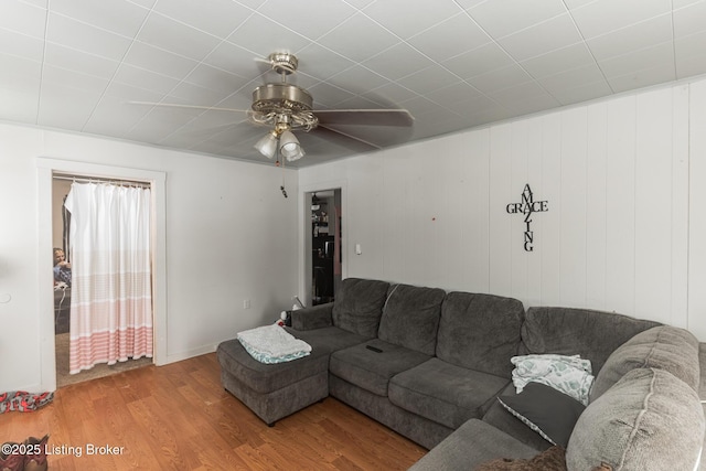 living area with a ceiling fan and wood finished floors