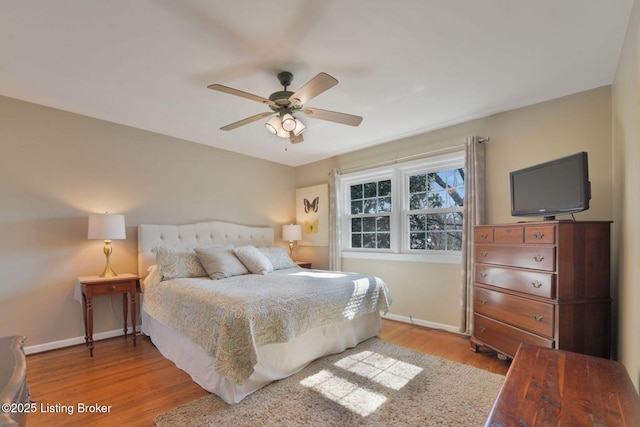 bedroom with ceiling fan, baseboards, and wood finished floors