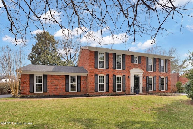 colonial house with brick siding and a front lawn