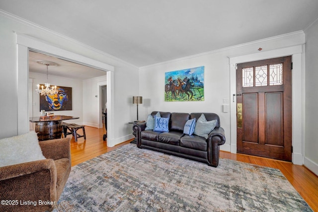 living area featuring a notable chandelier, ornamental molding, and wood finished floors