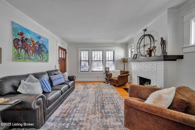 living area with a brick fireplace, wood finished floors, baseboards, and ornamental molding