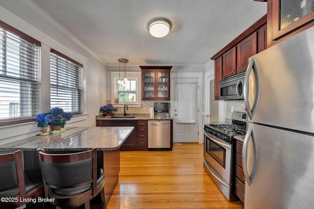 kitchen with stainless steel appliances, decorative backsplash, glass insert cabinets, crown molding, and light wood-type flooring