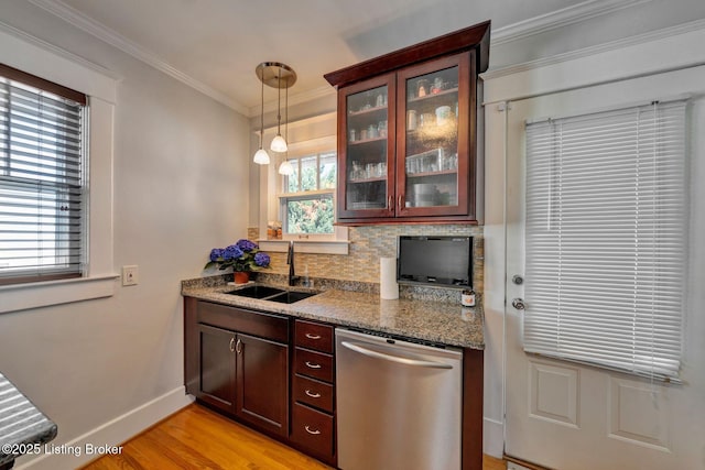 kitchen with tasteful backsplash, crown molding, dishwasher, light wood-type flooring, and a sink