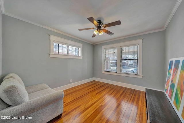 sitting room with baseboards, ornamental molding, and hardwood / wood-style flooring