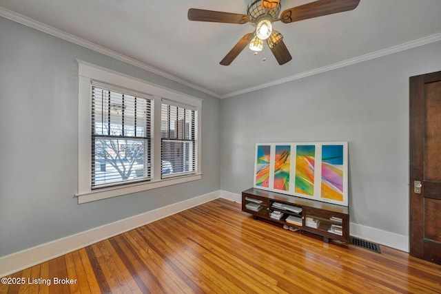 interior space featuring visible vents, ornamental molding, baseboards, and wood-type flooring