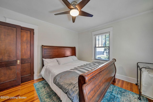 bedroom with light wood-style flooring, baseboards, ornamental molding, and a ceiling fan