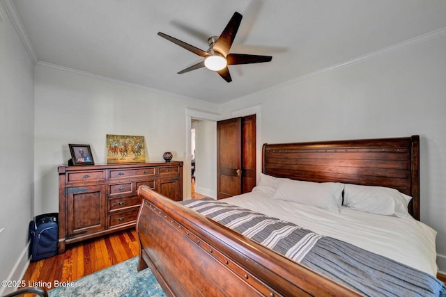 bedroom featuring ceiling fan, baseboards, wood finished floors, and ornamental molding