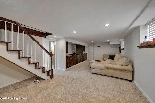 living area with recessed lighting, stairway, baseboards, and light colored carpet