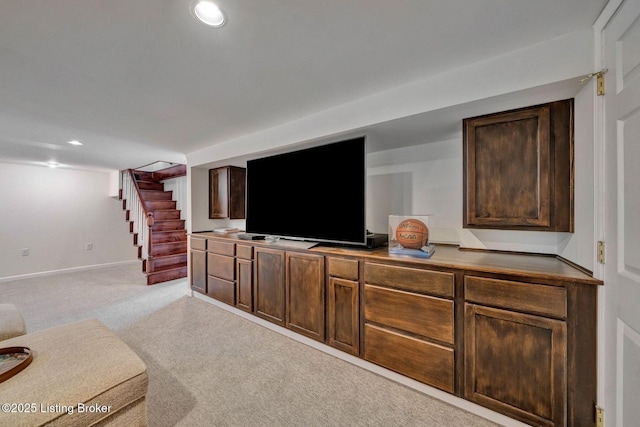 living area with stairs, recessed lighting, light colored carpet, and baseboards