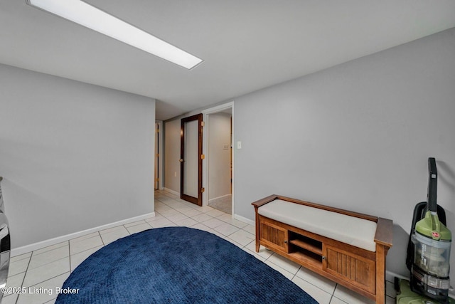 interior space featuring light tile patterned flooring and baseboards