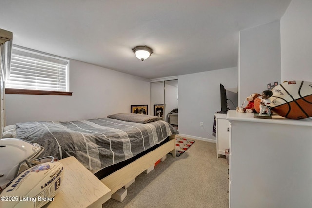 bedroom featuring light colored carpet, a closet, and baseboards