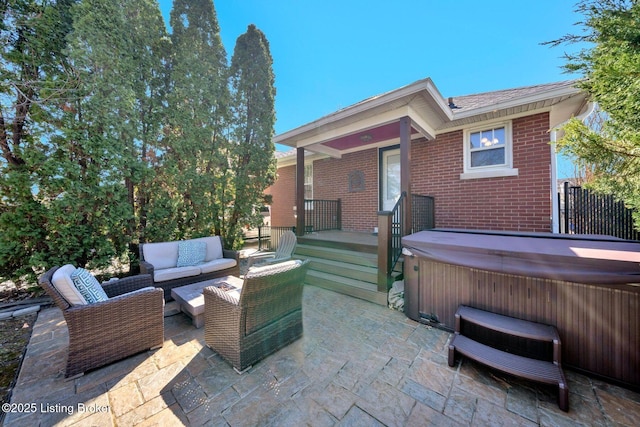 view of patio / terrace featuring an outdoor living space and a hot tub