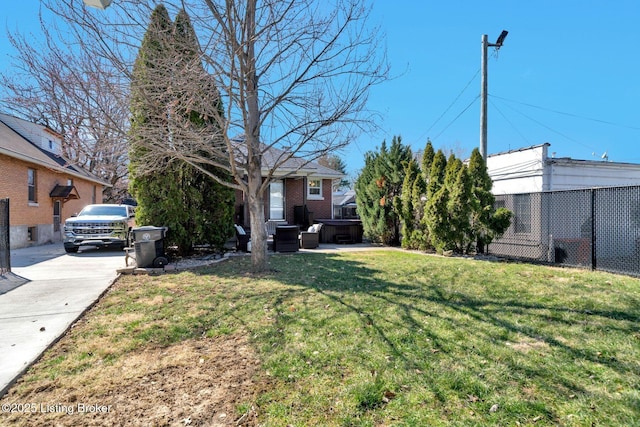 view of yard with fence and a hot tub