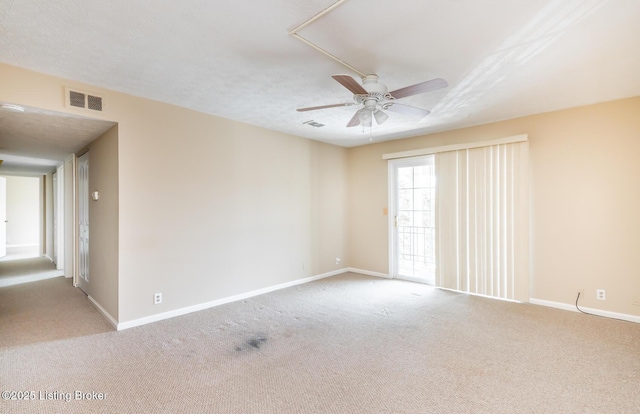 carpeted empty room featuring baseboards, visible vents, and ceiling fan