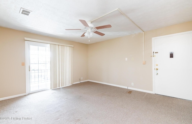 carpeted empty room with visible vents, a textured ceiling, baseboards, and ceiling fan