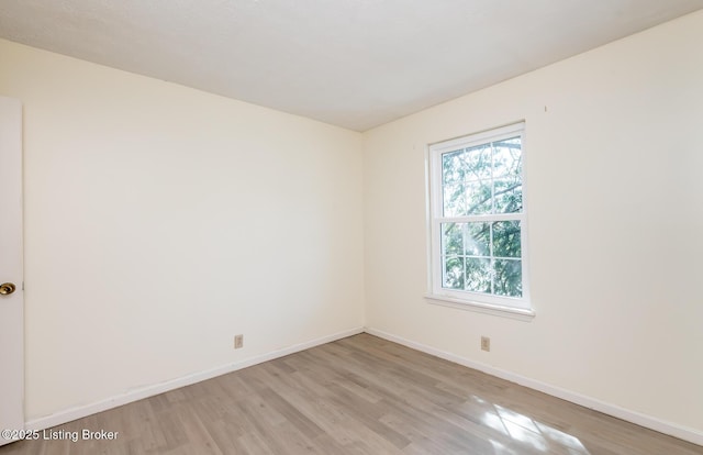 spare room with light wood finished floors and baseboards