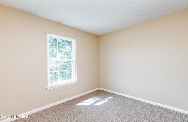 carpeted spare room with baseboards