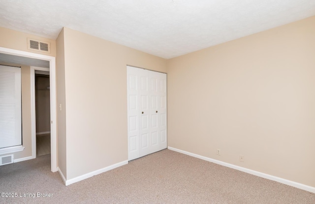 unfurnished bedroom featuring a closet, baseboards, visible vents, and carpet floors