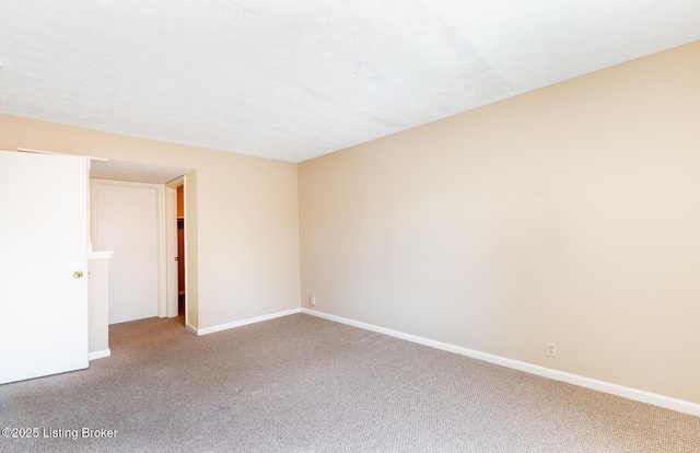 empty room with baseboards, carpet, and a textured ceiling