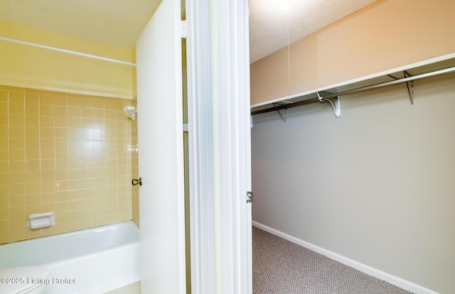 full bath with shower / bathing tub combination, baseboards, and a walk in closet