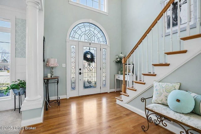 entrance foyer featuring plenty of natural light, wood finished floors, and decorative columns