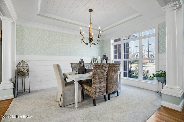 dining room featuring wallpapered walls, a raised ceiling, and decorative columns