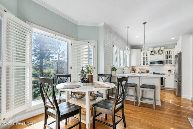 dining space with recessed lighting, light wood-type flooring, and ornamental molding