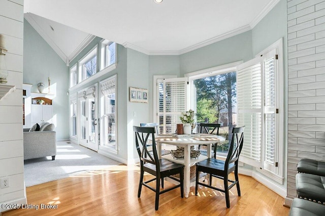 dining area with baseboards, wood finished floors, and ornamental molding