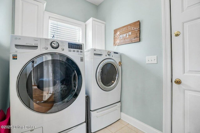 washroom with cabinet space, light tile patterned floors, washer and dryer, and baseboards