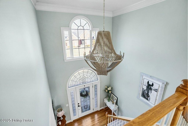 foyer entrance featuring ornamental molding, baseboards, and wood finished floors