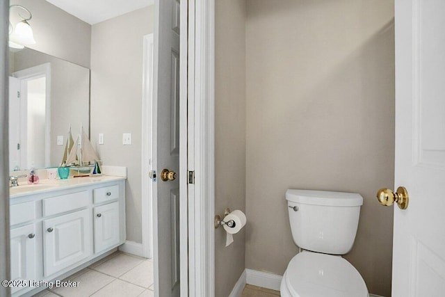 bathroom with vanity, toilet, baseboards, and tile patterned flooring