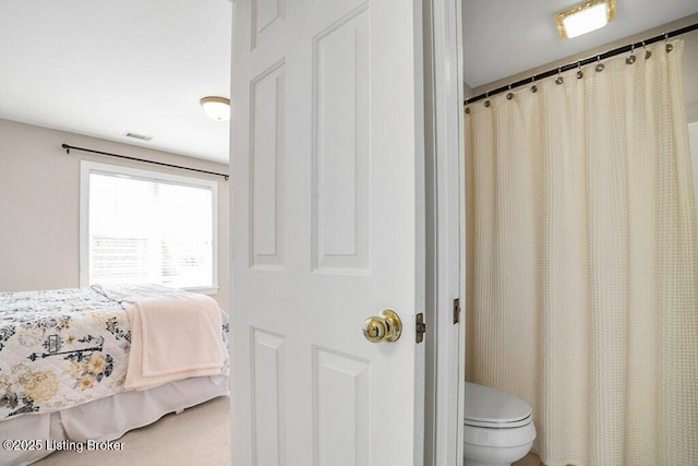 ensuite bathroom featuring connected bathroom, toilet, and visible vents