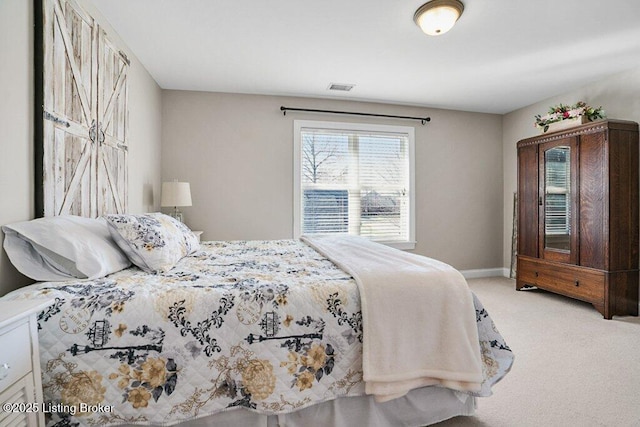 bedroom with baseboards, visible vents, and light carpet