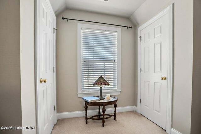 interior space featuring baseboards and light carpet