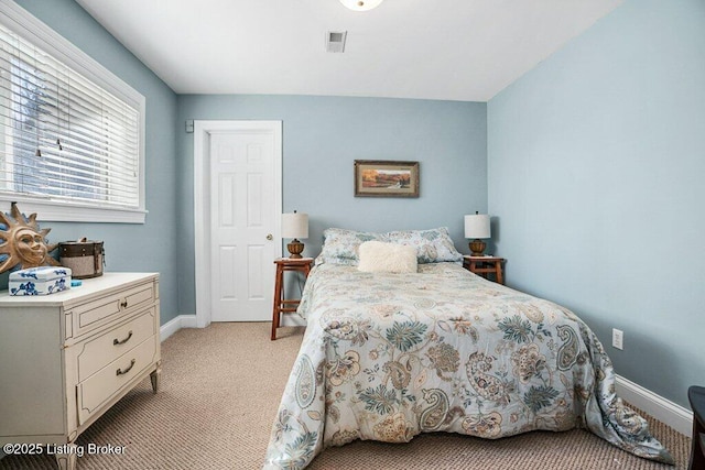 bedroom featuring baseboards, visible vents, and light carpet