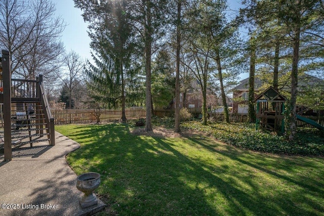 view of yard with stairway, a playground, and fence