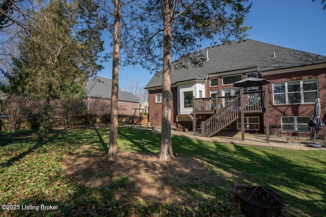 back of house with stairway, fence, a deck, a patio area, and a lawn