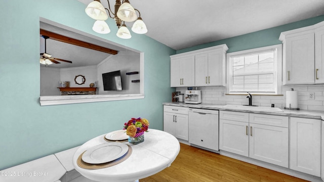 kitchen with white cabinetry, tasteful backsplash, white dishwasher, and a sink