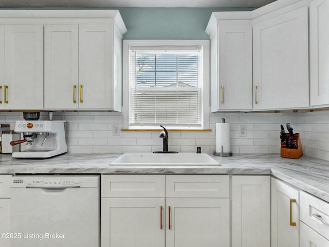 kitchen with decorative backsplash, white cabinets, dishwasher, and a sink