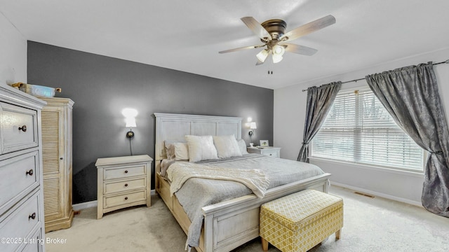 bedroom with a ceiling fan, baseboards, visible vents, and light carpet