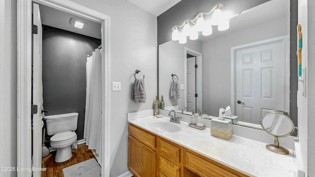 bathroom featuring toilet, vanity, and wood finished floors