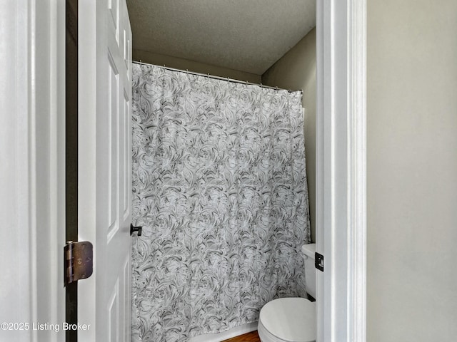 bathroom featuring toilet and a textured ceiling