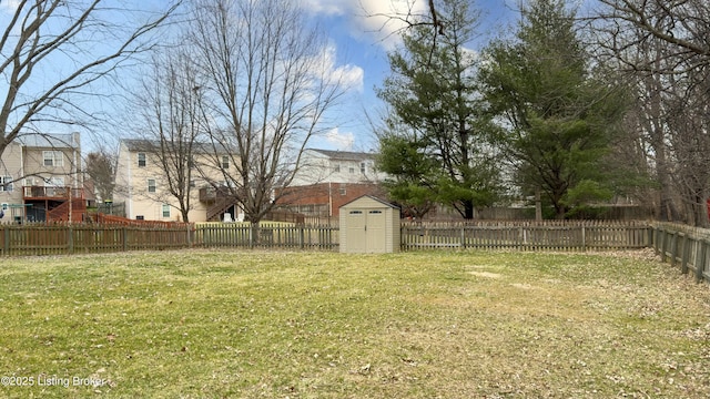 view of yard with a storage unit, an outbuilding, and a fenced backyard