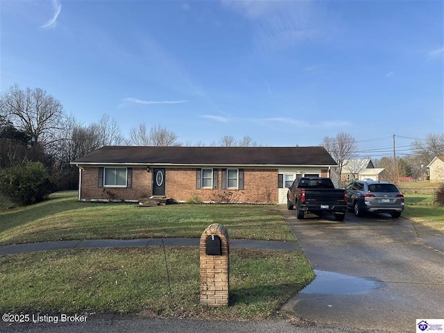 ranch-style house with a front yard, brick siding, and driveway