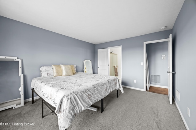 bedroom with visible vents, baseboards, ensuite bath, and carpet flooring